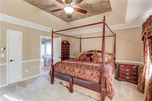 bedroom featuring ensuite bathroom, crown molding, ceiling fan, a raised ceiling, and light colored carpet