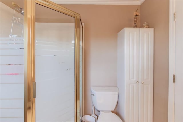 bathroom with ornamental molding, a shower with shower door, and toilet