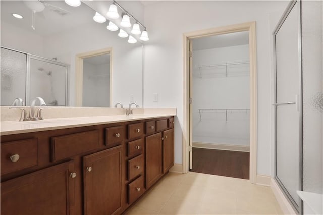 1585 Oak Meadows Ln, Cumming, GA 30041 - full bathroom featuring a shower stall, a walk in closet, double vanity, and a ceiling fan