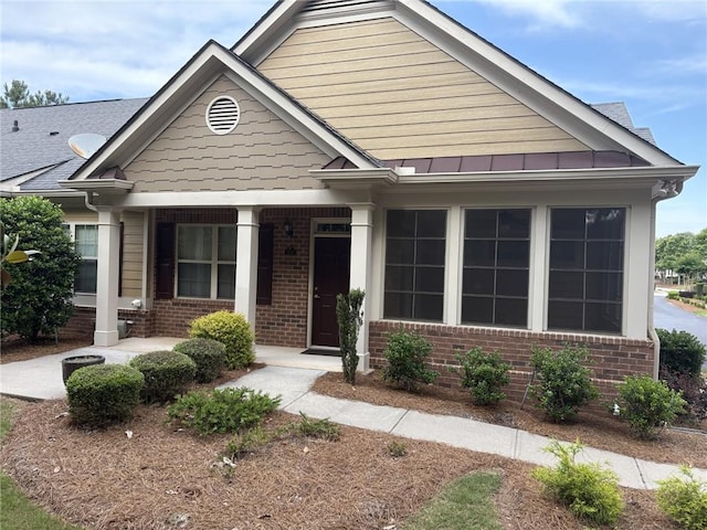 1585 Oak Meadows Ln, Cumming, GA 30041 - craftsman-style house featuring brick siding, a porch, and a standing seam roof