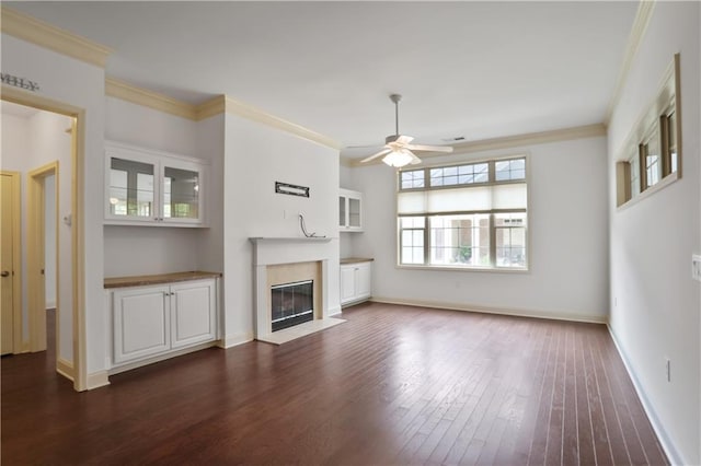 1585 Oak Meadows Ln, Cumming, GA 30041 - unfurnished living room with a ceiling fan, dark wood-style flooring, crown molding, and a fireplace with flush hearth
