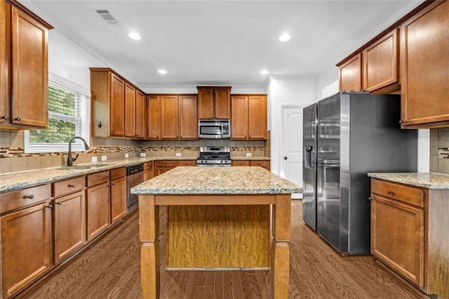 7601 Watson Cir, Locust Grove, GA 30248 - kitchen featuring appliances with stainless steel finishes, a sink, dark wood-style floors, crown molding, and decorative backsplash