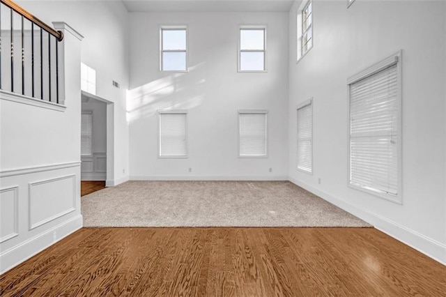 7601 Watson Cir, Locust Grove, GA 30248 - unfurnished living room with a high ceiling, wood finished floors, carpet, and baseboards