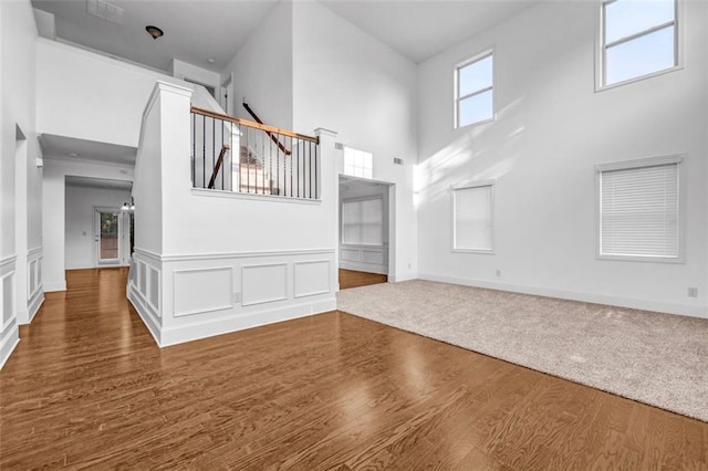 7601 Watson Cir, Locust Grove, GA 30248 - unfurnished living room with a towering ceiling, wood finished floors, and baseboards