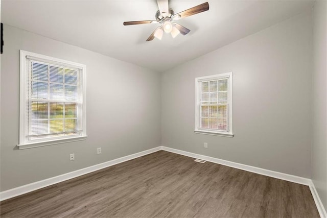 empty room with lofted ceiling, dark hardwood / wood-style floors, and ceiling fan