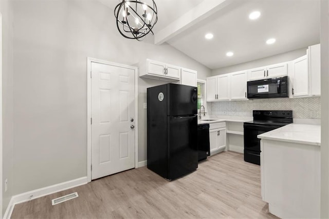 kitchen with white cabinets, black appliances, light wood-type flooring, and pendant lighting