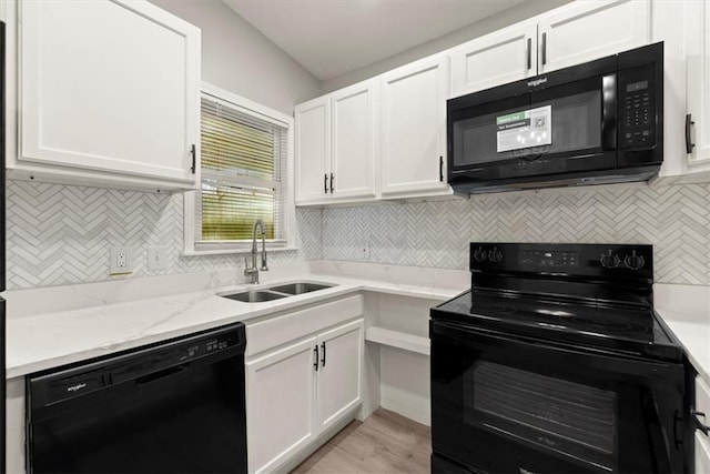 kitchen with white cabinetry, backsplash, black appliances, and sink