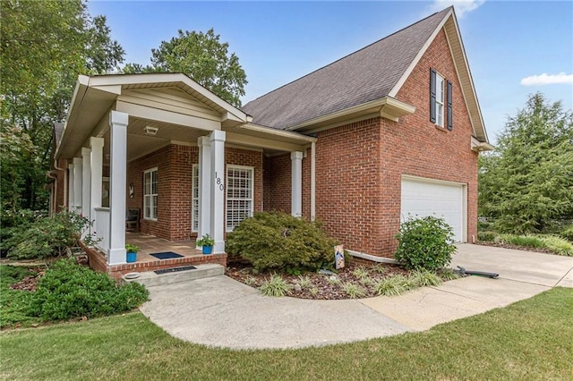 view of front of house featuring brick siding, a porch, concrete driveway, an attached garage, and a front lawn