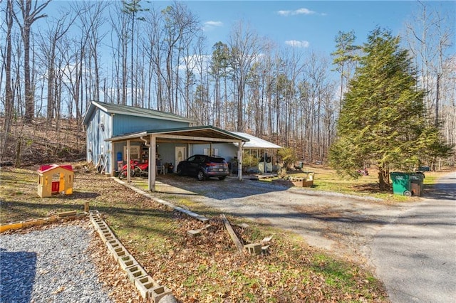 view of side of home featuring a carport and gravel driveway