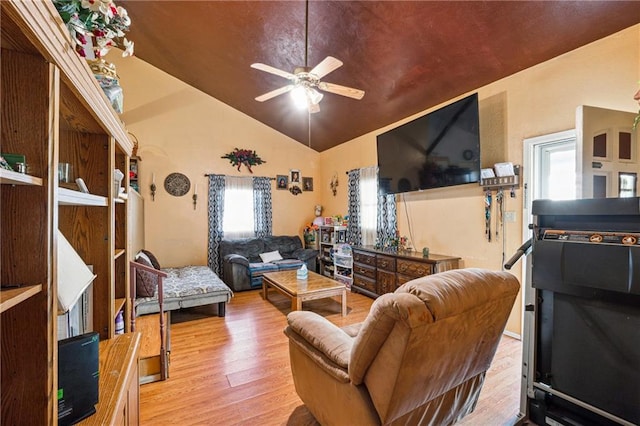 living room with lofted ceiling, wood finished floors, a ceiling fan, and a healthy amount of sunlight