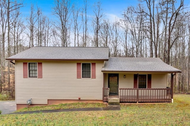 tri-level home with a porch, a front lawn, and a shingled roof