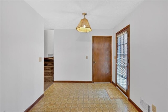 interior space with visible vents, baseboards, a healthy amount of sunlight, and stairway