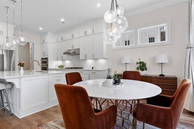 dining area featuring recessed lighting, wood finished floors, and ornamental molding