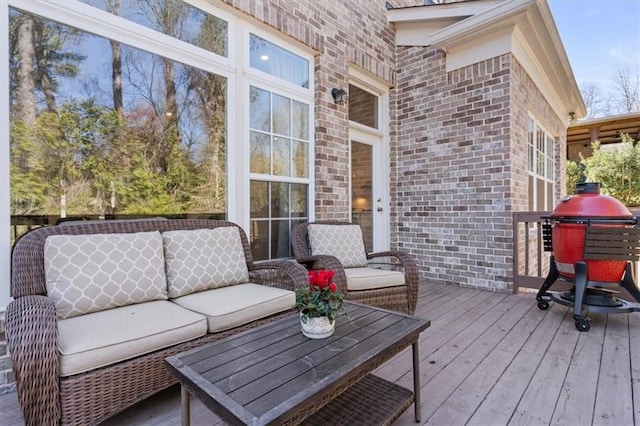 wooden terrace with an outdoor living space and grilling area