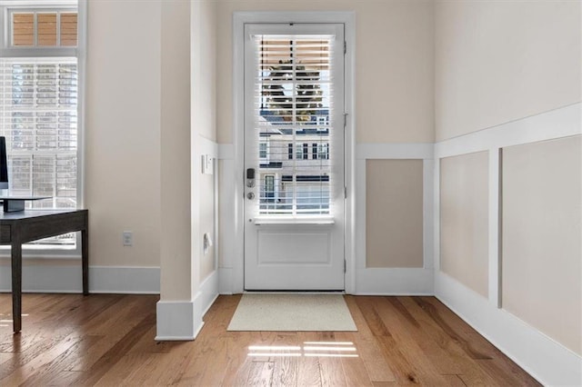 doorway to outside with baseboards and wood finished floors