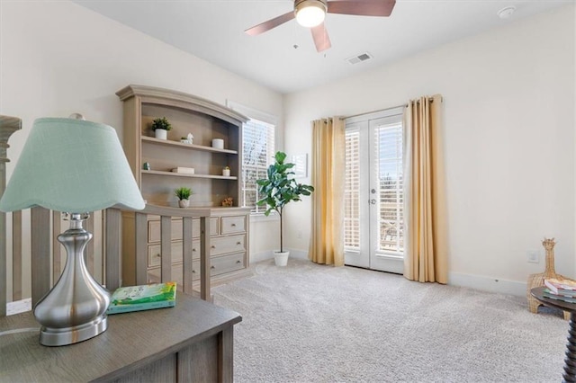 interior space featuring visible vents, baseboards, light colored carpet, and ceiling fan