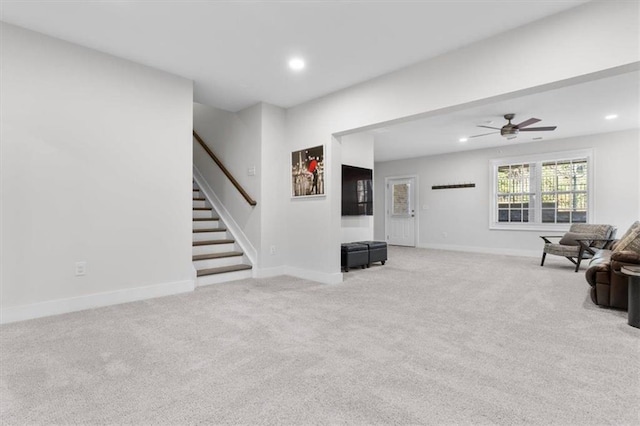 living room with recessed lighting, light colored carpet, and baseboards