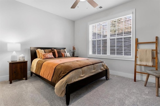 carpeted bedroom featuring visible vents, a ceiling fan, and baseboards