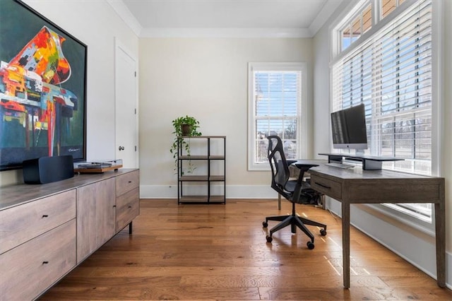 office with baseboards, wood finished floors, a healthy amount of sunlight, and ornamental molding