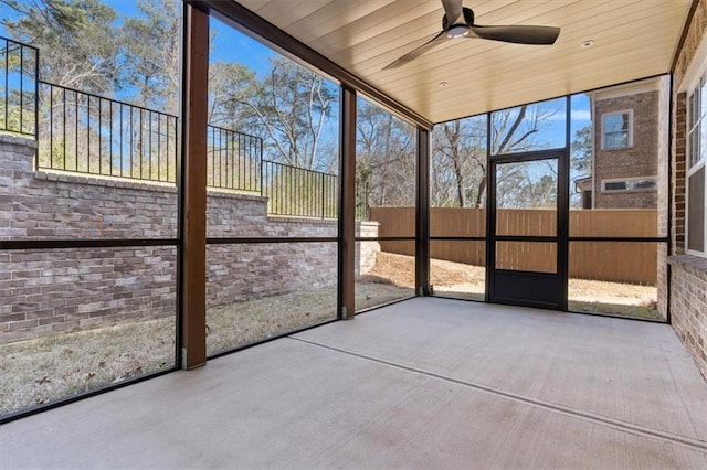 unfurnished sunroom featuring a ceiling fan