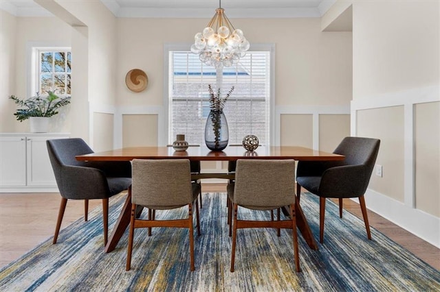 dining room featuring a healthy amount of sunlight, wainscoting, and crown molding