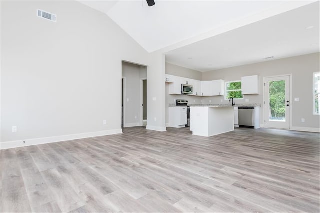 121 Hunters Ln, Powder Springs, GA 30127 - unfurnished living room with high vaulted ceiling, a ceiling fan, visible vents, light wood finished floors, and baseboards