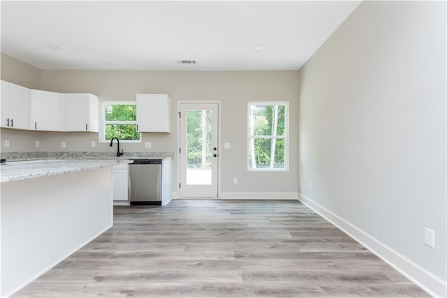 121 Hunters Ln, Powder Springs, GA 30127 - kitchen featuring stainless steel dishwasher, light wood-style flooring, white cabinetry, and light stone counters