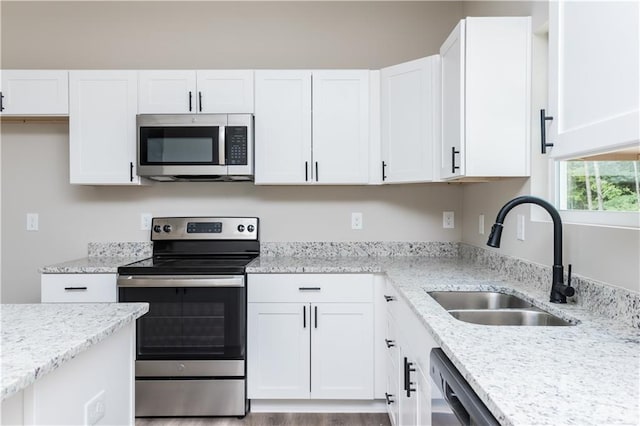 121 Hunters Ln, Powder Springs, GA 30127 - kitchen featuring a sink, white cabinets, light stone countertops, and stainless steel appliances