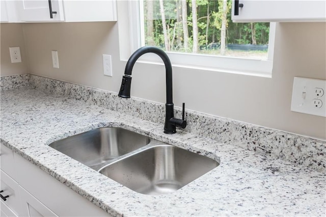 121 Hunters Ln, Powder Springs, GA 30127 - details featuring white cabinets, a sink, and light stone counters