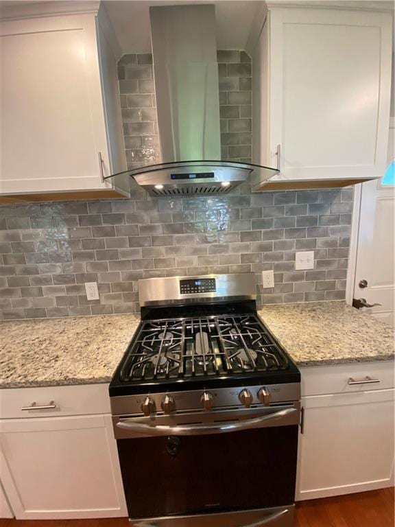 2319 Beecher Rd SW, Atlanta, GA 30311 - kitchen with wall chimney exhaust hood, gas stove, white cabinets, light stone counters, and tasteful backsplash