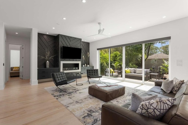 living room with recessed lighting, light wood-style flooring, ceiling fan, and baseboards