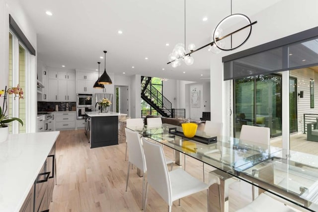 dining area with recessed lighting, light wood-style flooring, stairway, and a chandelier