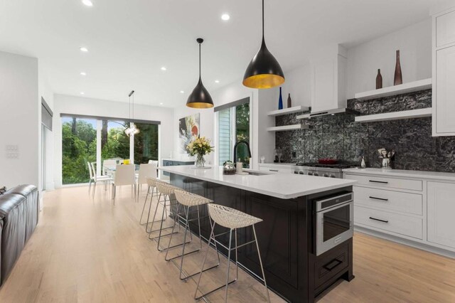 kitchen featuring open shelves, a sink, backsplash, stainless steel appliances, and white cabinets