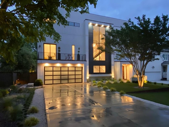 contemporary house with a balcony, driveway, and a garage