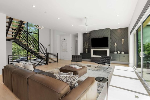 living room with stairs, light wood-style flooring, recessed lighting, and ceiling fan