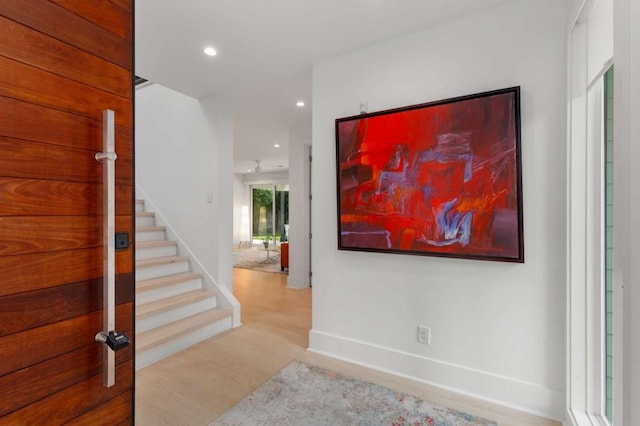 hall with stairs, wood finished floors, recessed lighting, and baseboards
