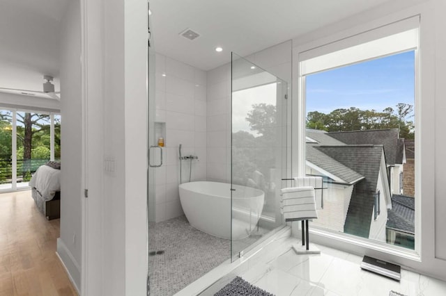 ensuite bathroom with a freestanding tub and recessed lighting