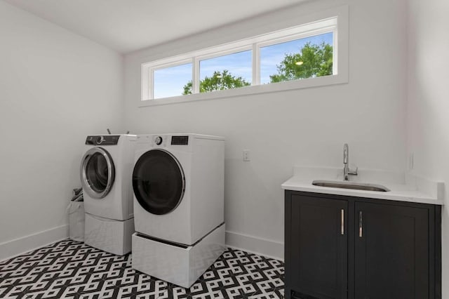 laundry area featuring cabinet space, washing machine and clothes dryer, baseboards, and wet bar
