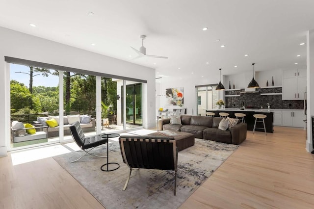 living room featuring recessed lighting, light wood-type flooring, and a ceiling fan