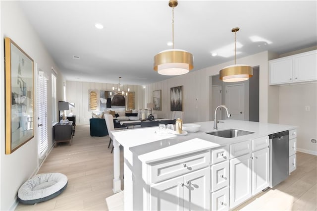 209 Chiswick Loop, Stockbridge, GA 30281 - kitchen featuring stainless steel dishwasher, white cabinets, light wood-type flooring, a kitchen island with sink, and light countertops
