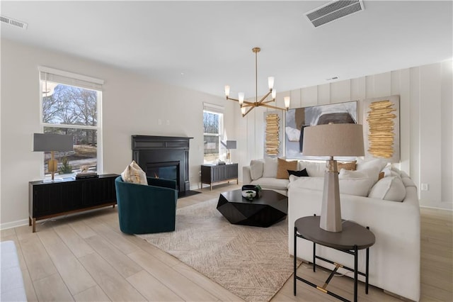 209 Chiswick Loop, Stockbridge, GA 30281 - living area featuring a chandelier, light wood-type flooring, and a fireplace with flush hearth