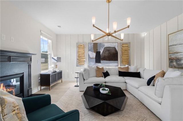 209 Chiswick Loop, Stockbridge, GA 30281 - living room with a chandelier, wood finished floors, and a glass covered fireplace
