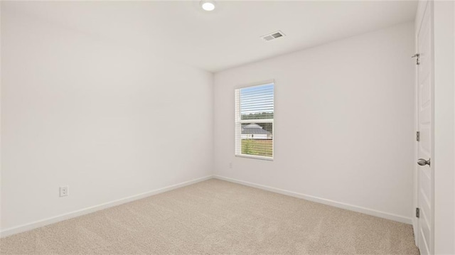 unfurnished room featuring light carpet, visible vents, and baseboards