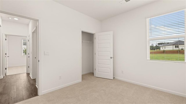 unfurnished bedroom featuring light colored carpet and a closet