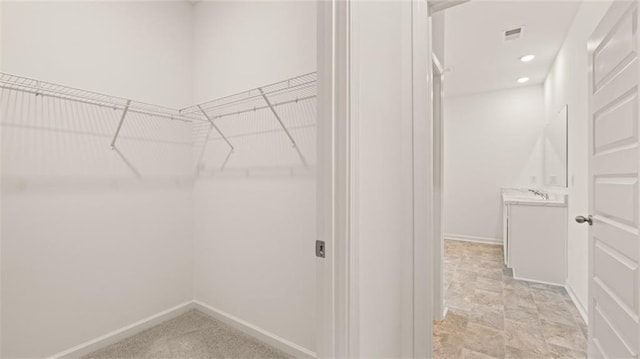 walk in closet featuring visible vents and a sink