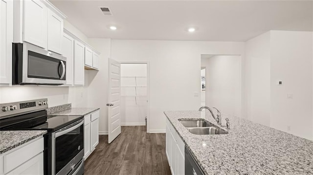 kitchen featuring appliances with stainless steel finishes, light stone counters, sink, dark hardwood / wood-style floors, and white cabinetry