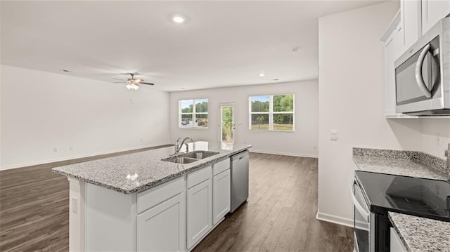 kitchen with appliances with stainless steel finishes, dark hardwood / wood-style flooring, sink, white cabinetry, and an island with sink