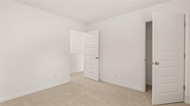 unfurnished bedroom with light carpet and a closet