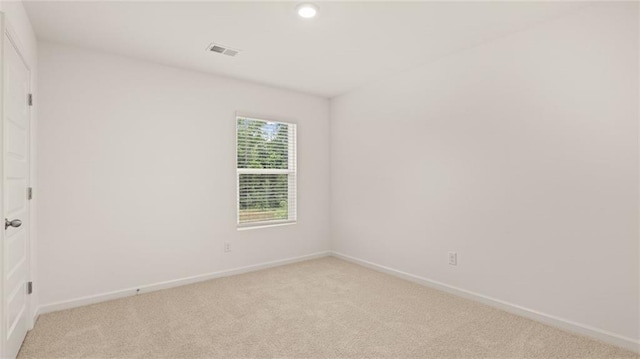 spare room featuring light carpet, recessed lighting, visible vents, and baseboards