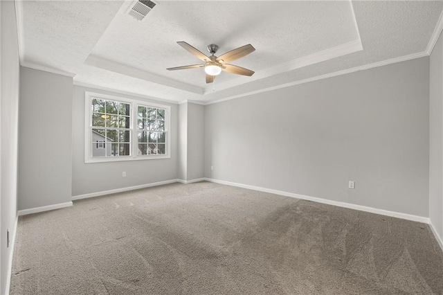 spare room featuring visible vents, a textured ceiling, a raised ceiling, and ornamental molding